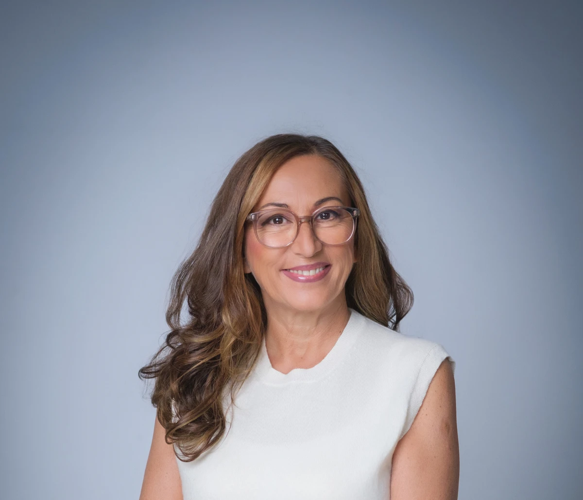 Dr. Isabella Wilden in weißem ärmellosem Oberteil, lächelnd